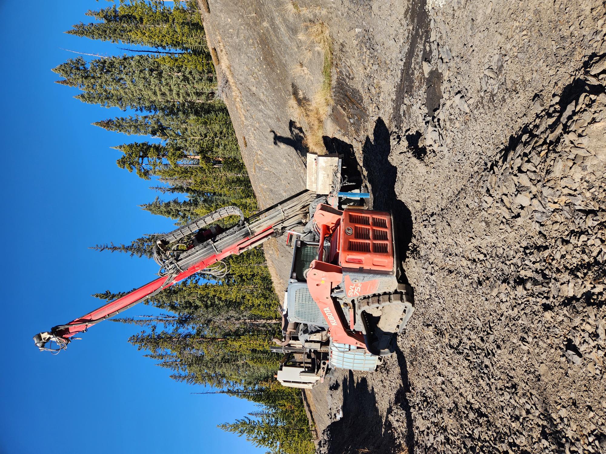 Excavator on dirt mound